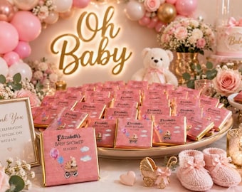 May include: A collection of rectangular chocolate bars wrapped in pink paper, each featuring the text 'Elizabeth's Baby Shower 10.11.2022' and an illustration of a baby in a carriage with balloons, arranged on a large platter for a baby shower event.