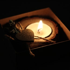 Pu&ograve; includere: Un cuore di legno con il testo "Grazie per aver celebrato il nostro giorno speciale" e una piccola candela in un portacandele di legno.