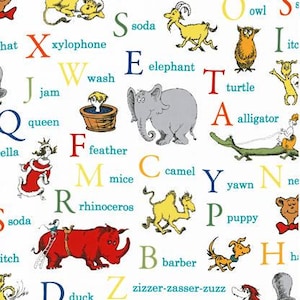 May include: A white fabric featuring a colorful alphabet with corresponding illustrations of animals and objects. Each letter has a matching word and image, such as "lion" and a lion illustration.
