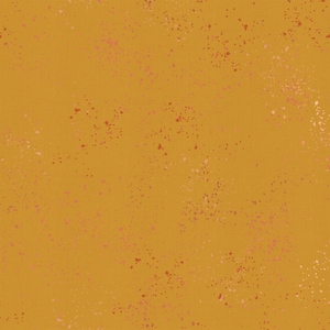 May include: Mustard yellow fabric with a speckled pattern. The fabric features small, irregular dots in shades of pink and red scattered across the surface. The overall effect is a textured, artistic design suitable for various craft projects.