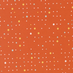 May include: Close-up of orange fabric with a pattern of white, yellow, and light blue dots. The dots are of varying sizes and are scattered across the surface. The fabric has a slightly textured appearance.