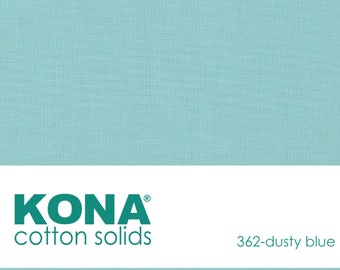 May include: A solid dusty blue Kona cotton fabric swatch. The fabric is a light blue color with a subtle texture. The text "KONA cotton solids 362-dusty blue" is printed on a white label below the fabric swatch.