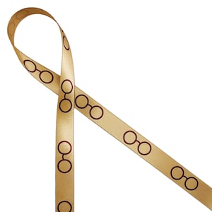 May include: Gold ribbon with a repeating pattern of brown glasses. The ribbon is tied in a loop.