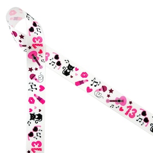 May include: White ribbon with a pink and black print of musical notes, hearts, lips, cats, sunglasses, and a guitar. The ribbon has the number "13" printed on it.