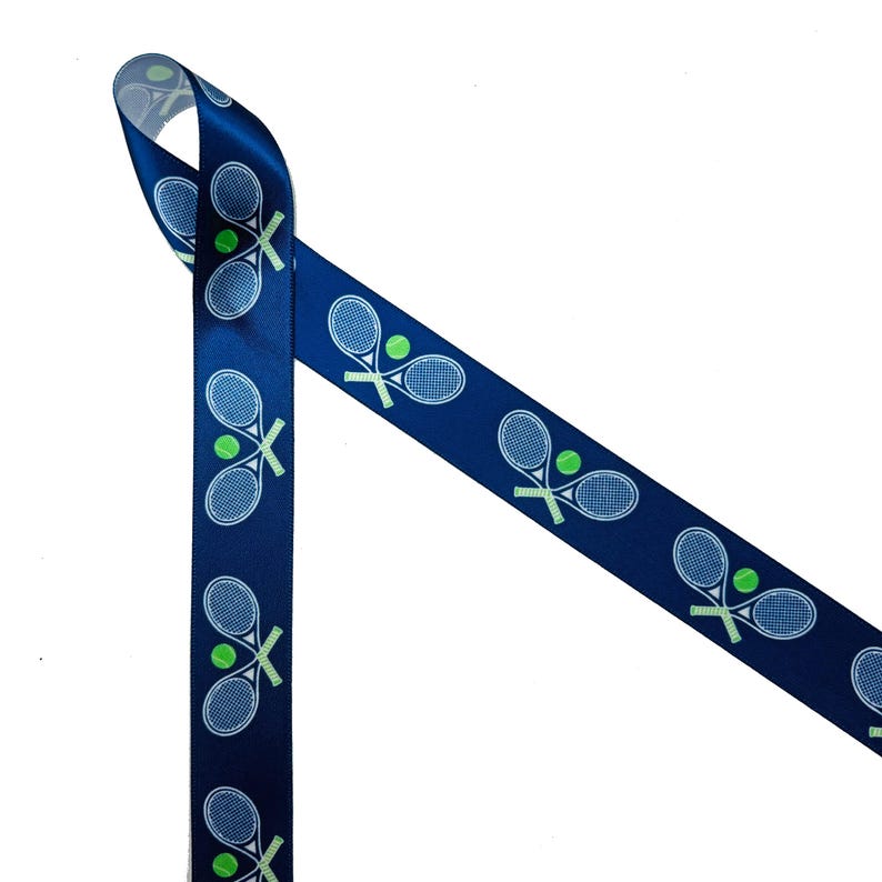 May include: A blue ribbon with a repeating pattern of white tennis rackets and green tennis balls.
