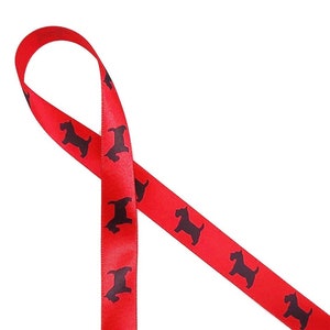 May include: Red satin ribbon with a repeating pattern of black dog silhouettes. The ribbon is looped and angled, showcasing the glossy texture and the contrasting colors of the design. Ideal for crafting or gift wrapping.