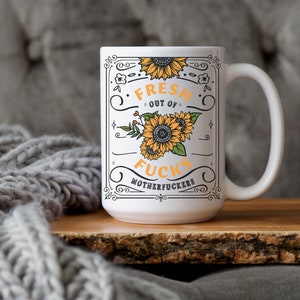 Fresh Out of Fcks mug with sunflower design, bold typography, geeky sweary drinkware.