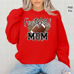 May include: Red sweatshirt with a football and leopard print design. The text "Football Mom" is printed on the sweatshirt.