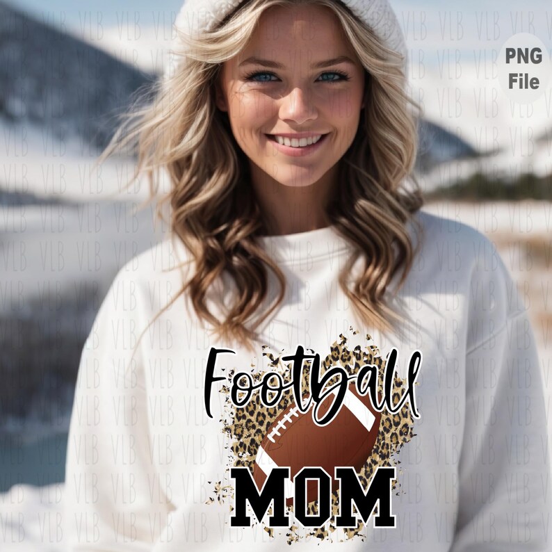 May include: White sweatshirt with a brown and black football graphic and the text "Football MOM" in black lettering on a leopard print background.