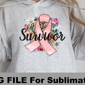 May include: A gray hoodie with a pink ribbon and floral design. The text "Survivor" is written in black cursive lettering.
