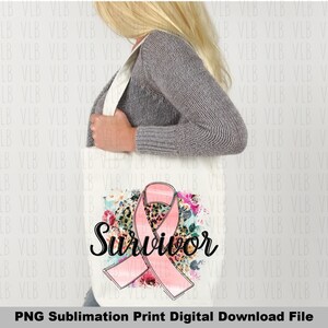 May include: A white tote bag with a pink ribbon, leopard print, and floral design. The text "Survivor" is written in black cursive lettering.