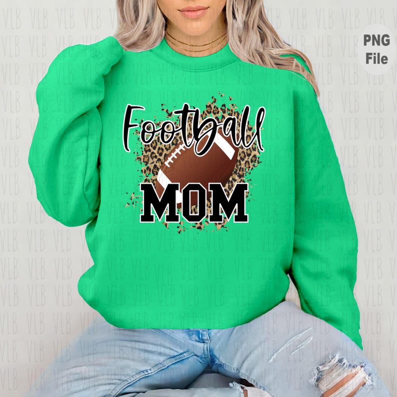 May include: Green sweatshirt with a black and brown football graphic and the text "Football Mom" in black.
