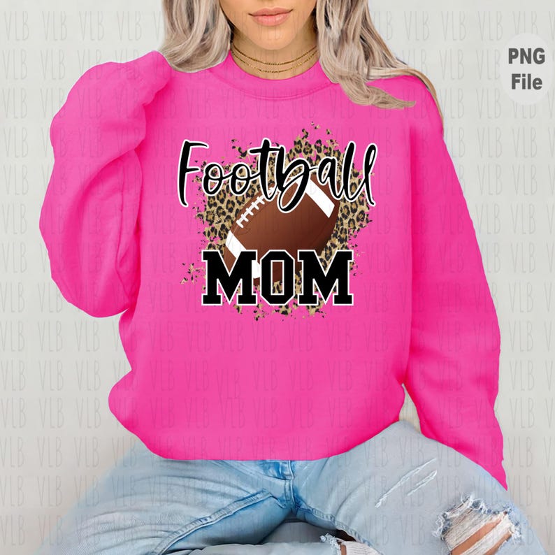 May include: Pink sweatshirt with a brown and black leopard print design featuring a football and the text "Football Mom".