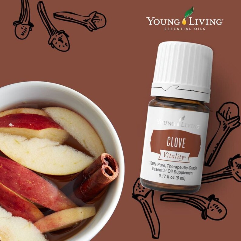 May include: A brown bottle of Young Living Clove Vitality essential oil, 0.17 fl oz (5 ml), with a white cap. The image includes a bowl of apple slices and a cinnamon stick, and clove illustrations.