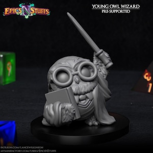 May include: A gray 3D-printed figurine of a young owl wizard. The owl wears round glasses, a cape, and holds a book and a wand. The figurine is on a black base. The text "YOUNG OWL WIZARD PRE-SUPPORTED" is above the owl.