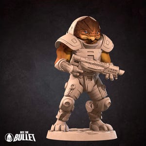 May include: A detailed figurine of a humanoid alien in futuristic armor, holding a rifle. The figure has a brown and tan head and arms, with white armor plating. The base is a light beige color, and the background is dark.