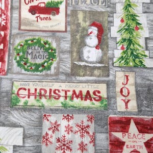 May include: A fabric panel featuring a collage of Christmas-themed images. The design includes a red truck carrying a Christmas tree, wreaths, snowmen, snowflakes, and text that reads "Christmas", "Peace on Earth", and "Believe in the Magic".