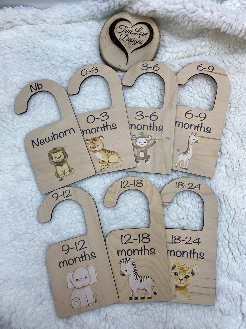 May include: Set of 7 wooden door hangers with animal illustrations and age ranges for babies, including Newborn, 0-3 months, 3-6 months, 6-9 months, 9-12 months, 12-18 months, and 18-24 months.