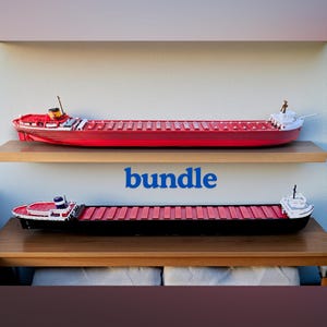 Może przedstawiać: Dwa modele statków towarowych, jeden czerwony i jeden czarny, wystawione na drewnianych półkach. Czerwony statek znajduje się na górnej półce, a czarny na dolnej. Słowo "bundle" jest napisane na niebiesko między półkami.