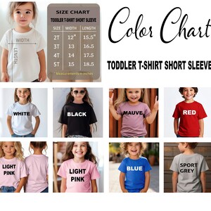 May include: A color chart for toddler short sleeve t-shirts. The chart includes a size guide with measurements in inches and examples of t-shirts in various colors: white, black, mauve, red, light pink, blue, and sport grey.