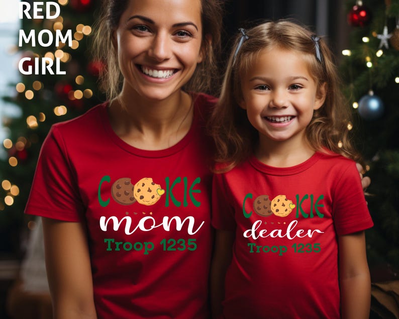May include: Two people wearing matching red t-shirts with cookie-themed designs. One shirt says "Cookie Mom" and the other says "Cookie Dealer". Both shirts have a cookie graphic and the text "Troop 1235". The text "RED MOM GIRL" is in the top left corner.