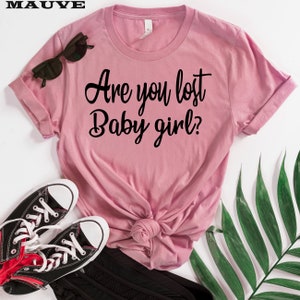May include: A pink t-shirt with the text "Are you lost Baby girl?" printed in black.