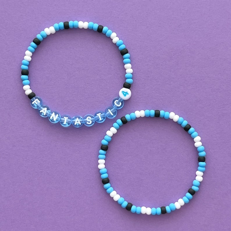 May include: Two beaded bracelets, one with the word "FANTASTIC" and the number "4" in white beads, and the other with alternating black, white, and blue beads.