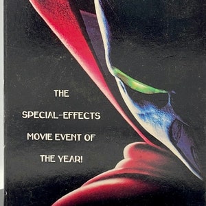 May include: A VHS tape case for the film Spawn. The case features a black background with a red and blue image of the Spawn character. The text on the case reads "Spawn", "The Special-Effects Movie Event of the Year!" and "Born in Darkness. Sworn to Justice."