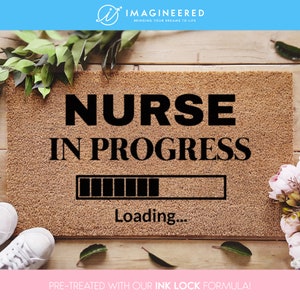 May include: A brown coir doormat with the text "NURSE IN PROGRESS" and a loading bar graphic. The text "Loading..." is below the bar. The doormat is pre-treated with an ink lock formula.