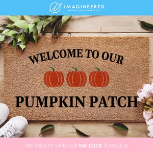 May include: A brown coir doormat with the text "Welcome to our Pumpkin Patch" in black lettering. Three orange pumpkins are depicted in the centre of the text. The doormat is pre-treated with an ink lock formula.