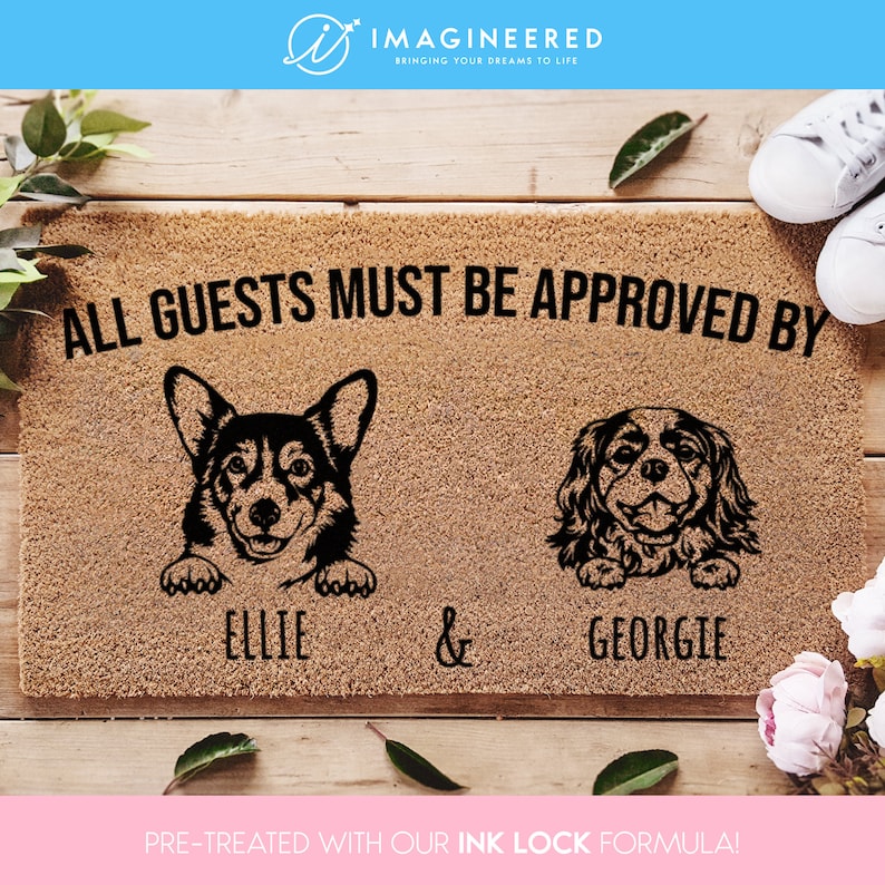 May include: A brown doormat with the text "ALL GUESTS MUST BE APPROVED BY" and the names "ELLIE & GEORGIE" printed on it. Two dog silhouettes are shown, a corgi and a cavalier king charles spaniel.