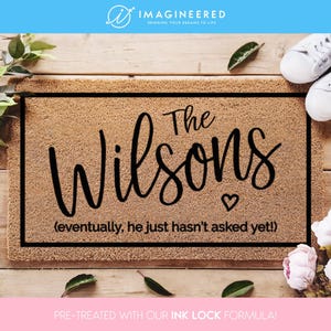 Puede incluir: Una alfombra de coco marrón con texto negro que dice "The Wilsons (eventually, he just hasn't asked yet!)".