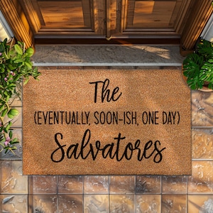 May include: A brown coir doormat with the text "The (eventually, soon-ish, one day) Salvatores" in black.