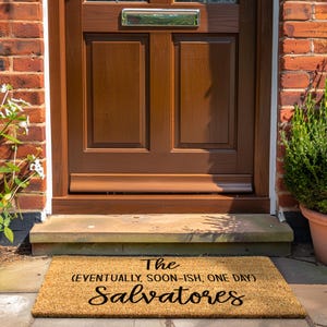 May include: A brown coir doormat with the text "The (eventually, soon-ish, one day) Salvatores" in black.