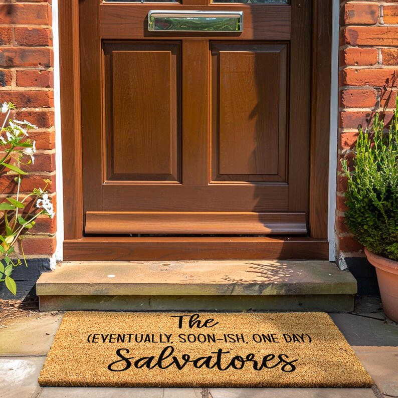 May include: A brown coir doormat with the text "The (eventually, soon-ish, one day) Salvatores" in black.