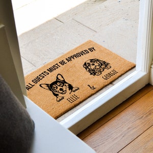 May include: A brown coir doormat with the text "ALL GUESTS MUST BE APPROVED BY" and two dog silhouettes with the names "Ellie" and "George" underneath.