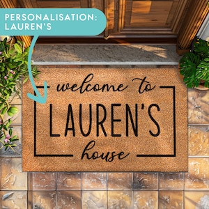 Puede incluir: Una alfombra de coco marrón con un borde negro y el texto "welcome to LAUREN'S house" en una fuente manuscrita.