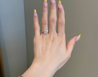 May include: A hand with gold tipped nails wearing a diamond engagement ring and a gold chain bracelet.