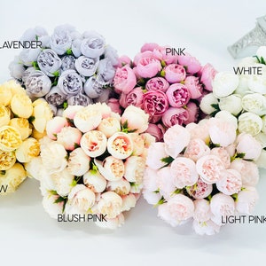 May include: Assortment of artificial flower bouquets in various colors, including lavender, pink, white, yellow, blush pink, and light pink. Each bouquet is made up of small, delicate flowers.