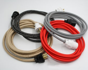 May include: Four spools of electrical cord with different colored fabric coverings. The cords are red, black and white striped, beige, and gray. Each cord has a plug and a socket.