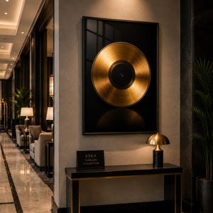 Può includere: Un'opera d'arte incorniciata con un disco in vinile dorato su sfondo nero è appesa sopra una consolle nera. Una piccola lampada con paralume dorato e base nera è sul tavolo. Il tavolo ha un'insegna con la scritta "ETRA TIMELESS COLLECTION".