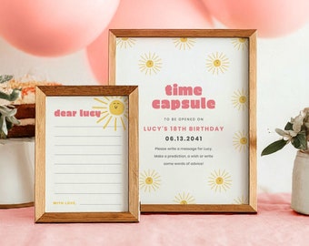 May include: Two framed cards with a sun design. The larger card says "time capsule" and has instructions to be opened on Lucy's 18th birthday, 06.13.2041. The smaller card says "dear lucy" and has lines for writing a message.