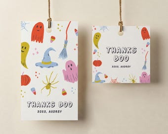 May include: Two white Halloween-themed gift tags with a variety of colorful illustrations. The tags feature ghosts, witch hats, spiders, candy corn, and the text "THANKS BOO XOXO, AUDREY". The tags are suspended by brown twine.