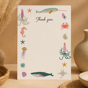 May include: A rectangular white card with the text Thank you printed in the center. The card features a border of colorful illustrations including a narwhal, squid, seahorse, jellyfish, crab, whale, stingray, starfish, and various seashells.