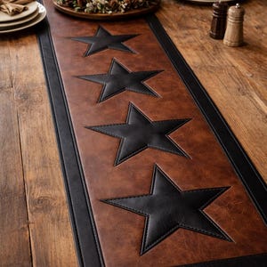 May include: Brown leather table runner with black star detailing. The runner features a black border and is displayed on a wooden table. The stars are evenly spaced, providing a decorative element to the dining setting.
