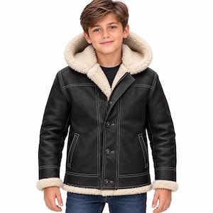 May include: A black jacket with a white faux-shearling lining and hood. The jacket features a front button closure, long sleeves with shearling cuffs, and visible white topstitching details along the seams and pockets. The hem is also lined.