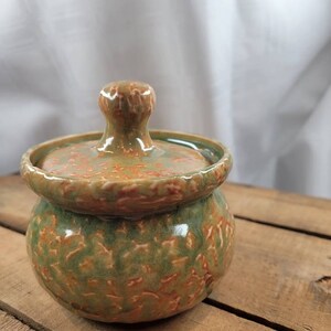 Orange-green textured pottery jar