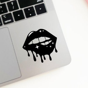 May include: Black lips with white stars and dripping black paint. The lips are open and show teeth.