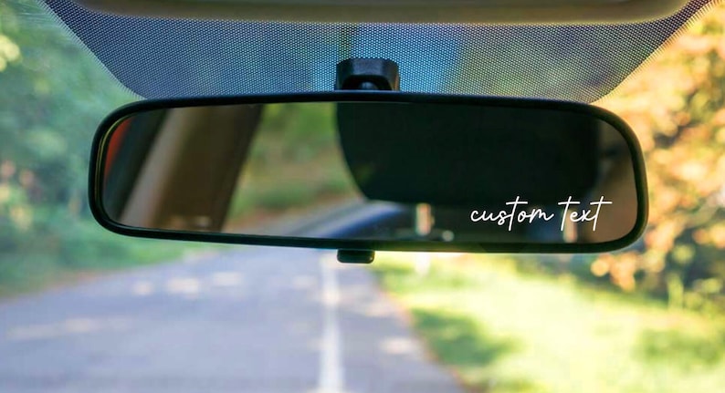 K&ouml;nnte beinhalten: Ein R&uuml;ckspiegel mit einem wei&szlig;en Vinyl-Aufkleber mit der Aufschrift "custom text".