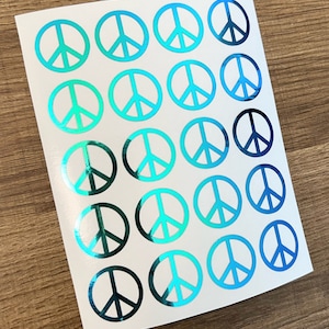 May include: A sheet of 20 peace sign stickers with a holographic finish. The stickers are iridescent blue and green.